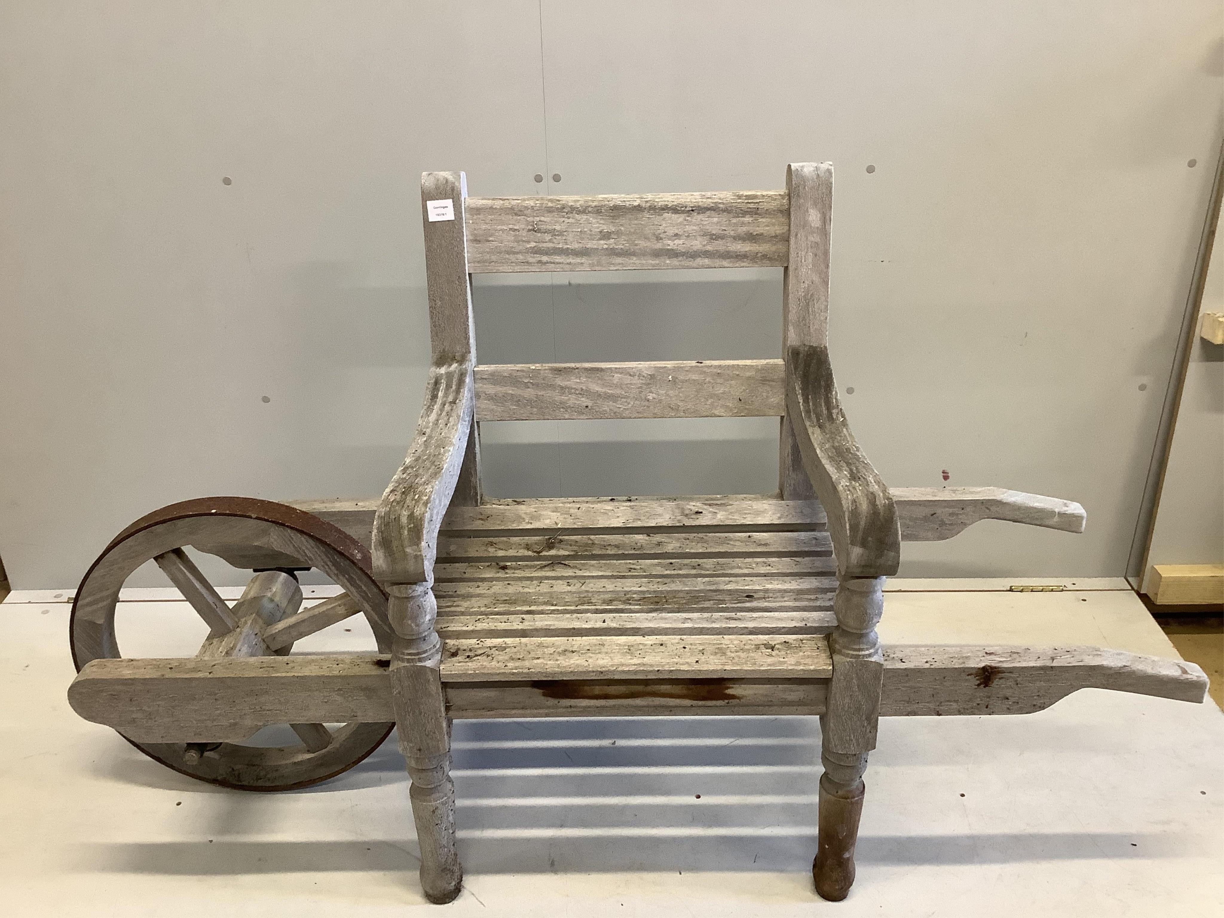 An Andrew Crace weathered teak wheel barrow garden bench. width 166cm, depth 58cm, height 96cm. Condition - fair to good